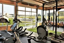 Vue intérieure d'un gym commercial avec une porte de garage toute vitrée California  12' x 10' avec cadre en aluminium anodisé