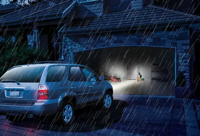Une auto entrant dans le garage, la porte de garage a ouvert même s'il y a une panne de courant  grâce à la batterie de secours de l'ouvre-porte de garage LiftMaster